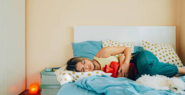 Fille allongée sur lit avec bouillote, douleurs bas ventre - Endométriose