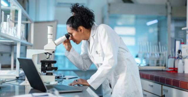 Scientifique qui regarde dans un microscope dans un laboratoire - Hépatite associée à l'alcool - Hôpital universitaire de Bruxelles