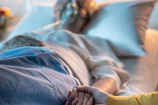 Service de Gériatrie - Hôpital Universitaire de Bruxelles - Illustration femme hospitalisée donne la main à son proche